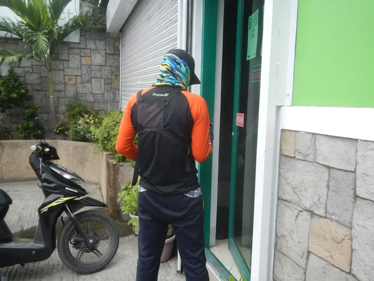 Delivery rider at a door with a parcel